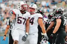  ?? WINSLOW TOWNSON/AP PHOTO ?? UConn defensive lineman Cole Ormsby (57) celebrates a sack with Kevin Murphy during the second half of the Huskies’ 20-9 win over Cincinnati on Saturday in an American Athletic Conference game at Rentschler Field in East Hartford.