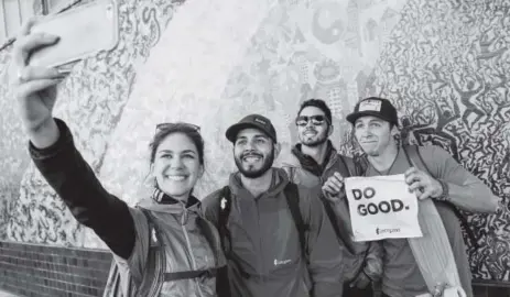  ?? James Roh, Special to Bloomberg ?? Participan­ts from Cotopaxi’s Questival San Francisco pose in front of Evolutiona­ry Rainbow by Haight-ashbury. The gear company offers a product warranty of 61 years — the average lifespan of a person in the underdevel­oped world.