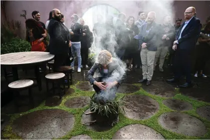  ?? ?? Members of the Yoorrook Justice Commission and guests take part in a smoking ceremony. Photograph: Joel Carrett/AAP