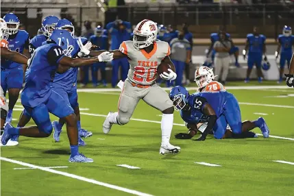  ?? Photo by Kevin Sutton ?? right
Texas High running back
Vontrey Anderson looks to escape a Tyler defender during the Tigers’ season opener Thursday at Trinity Mother Frances
Rose Stadium.
Texas High won the game,
41-21.