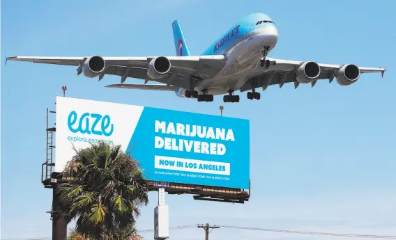  ?? Mario Tama / Getty Images 2018 ?? A billboard near Los Angeles Internatio­nal Airport advertises the marijuana delivery service Eaze. Such billboards are now banned on interstate highways.