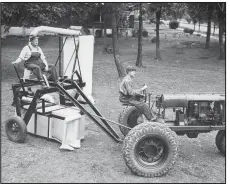  ?? AP file photo ?? The inventors of the new Rust pull-model cotton picker, John D. Rust (left, on the picker) and Mack D. Rust (right, on tractor) in a 1935 photograph.