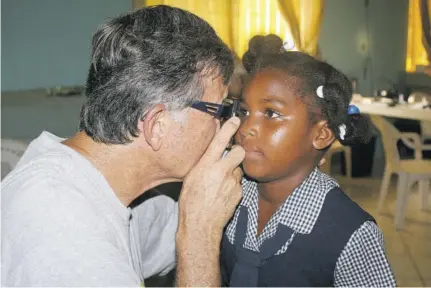  ?? ?? A Great Shape! Inc volunteer conducts an eye exam on a child during one of its clinics.
