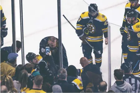  ?? STAFF PHOTOS BY NICOLAUS CZARNECKI ?? DIVERGING SCENES: Above, defenseman Brandon Carlo is taken off the ice on a stretcher following an ugly fall during the third period of yesterday’s Bruins victory against Florida at the Garden. Below, Charlie McAvoy, who could return soon from an...