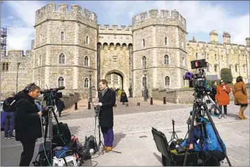  ?? Alberto Pezzali Associated Press ?? WITH THE cancer diagnoses of King Charles III and the Princess of Wales, the thinning ranks of working British royals cast uncertaint­y on the monarchy’s future. Above, a reporter at Windsor Castle on Saturday.