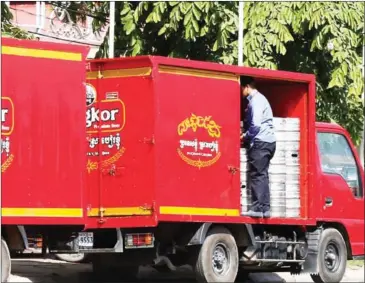  ?? HENG CHIVOAN ?? A Cambrew employee unloads kegs of Angkor beer from a company truck in May 2014.
