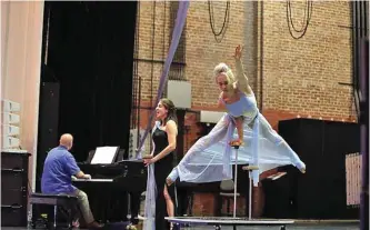  ?? — AP photos ?? Hand balancer Gretchenin­Motion, right, soprano Christina Vial and pianist Michael Borowitz rehearse to Puccini’s ‘Chi il bel sogno di Doretta’ for Opus Opera, pairing circus acrobatics and opera, in New Orleans.