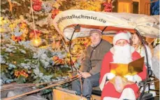  ??  ?? Mit dem Weihnachts­mann auf dem Kutschbock wird vor dem Christbaum am Rathaus gemeinsam gesungen.