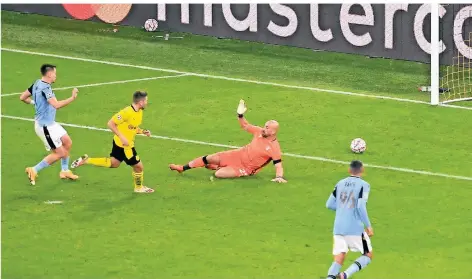  ?? FOTO: BERND THISSEN/DPA ?? Dortmunds Raphael Guerreiro erzielt das Tor zum 1:0 gegen Lazios Torwart Pepe Reina.
