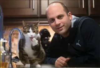  ?? MATHEW MCCARTHY, RECORD STAFF ?? Greg Nowak with his cat, Survivor, at their home.