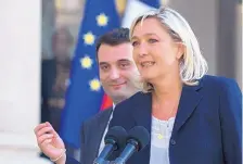  ?? JACQUES BRINON/ASSOCATED PRESS ?? French far-right National Front President Marine Le Pen and VicePresid­ent Florian Philippot, left, talk to the media in Paris. Gay support has helped Le Pen rebrand the formerly fringe, neo-Nazi party.