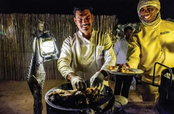  ?? RENÉE S. SUEN PHOTOS ?? Experience a Bedouin meal under the desert sky that might include a flight of Arabic mezze (appetizers) and lamb ouzi wrapped in palm leaves after being cooked undergroun­d for 24 hours.