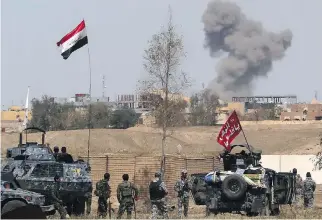  ?? KHALID MOHAMMED/THE ASSOCIATED PRESS ?? Iraqi security forces prepare to attack ISIL positions Friday as smoke rises from central Tikrit, 130 kilometres north of Baghdad.