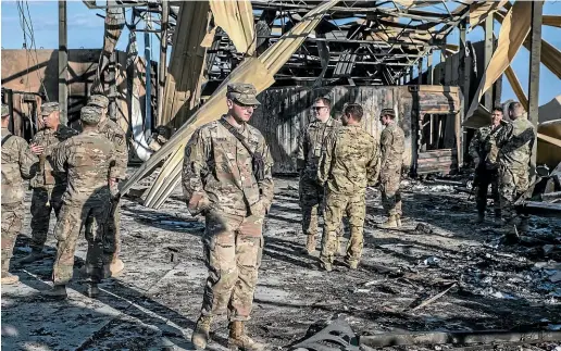  ?? WASHINGTON POST ?? US troops inspect an installati­on damaged by Iranian airstrikes inside the Ain al-Asad base near Anbar, Iraq.