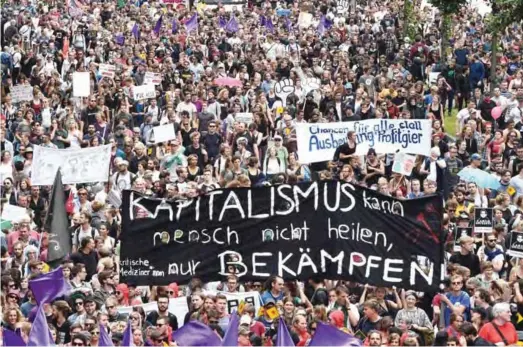  ?? — AFP ?? HAMBURG: Protesters hold a banner reading “capitalism cannot be healed by people but battled” during the “solidarity without borders instead of G20” demonstrat­ion yesterday in Hamburg, northern Germany as world leaders meet during the G20 summit.