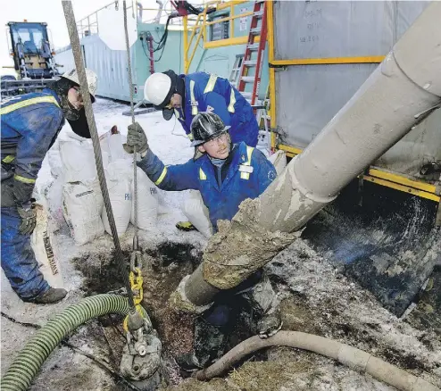  ?? NORM BETTS / BLOOMBERG NEWS FILES ?? Driller Ian Van Egmond, centre, on a Precision Drilling rig at an Encana well near Alix, Alta., in happier days in 2009.