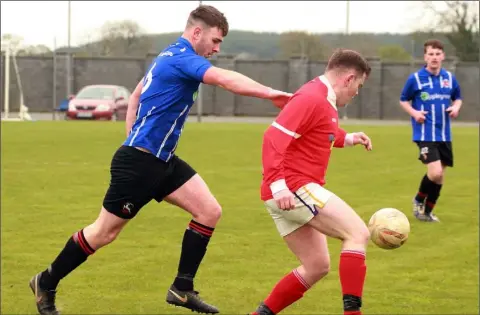  ??  ?? David Curley of Gorey Rangers tracks Eoin Furlong of Raheen during their Division 3 match.