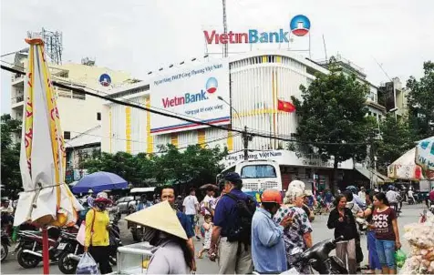  ?? Bloomberg ?? Poor risk-reward profile A branch of Vietin Bank in Ho Chi Minh City. Vietnam, a frontier market, has seen its credit rating downgraded by Moody’s over the past decade.