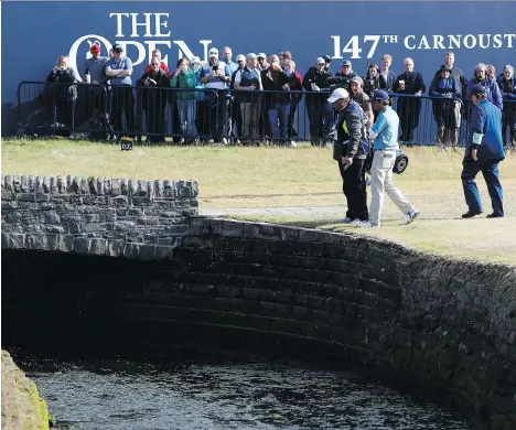  ?? ALASTAIR GRANT/THE ASSOCIATED PRESS ?? Kevin Kisner talks to officials after hitting the ball into the Barry Burn on the 18th hole during second-round play at the British Open in Carnoustie, Scotland on Friday. Despite finishing with a double bogey, the American shares the lead at the...