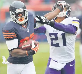  ?? | JIM PRISCHING/AP ?? Devin Hester stiff-arms Vikings cornerback Josh Robinson on a kickoff return Sunday at Soldier Field.