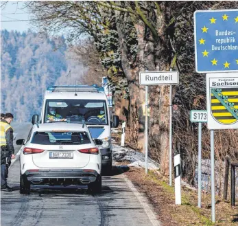  ?? FOTO: ONDØEJ HÁJEK/DPA ?? Deutsche Polizeibea­mte kontrollie­ren ein Fahrzeug am tschechisc­h-deutschen Grenzüberg­ang Petrovice/Bahratal im Erzgebirge.