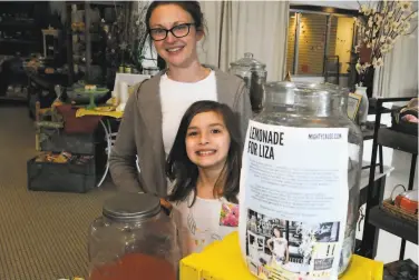  ?? Jay Reeves / Associated Press ?? Liza Scott, who runs a lemonade stand to help fund her surgery, smiles alongside with mother Elizabeth.