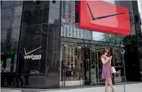  ??  ?? A pedestrian uses a smartphone outside a Verizon Communicat­ions store. Verizon has a simple goal in buying Yahoo’s core business: It wants to challenge Google and Facebook in the huge and lucrative field of digital advertisin­g. — Bloomberg