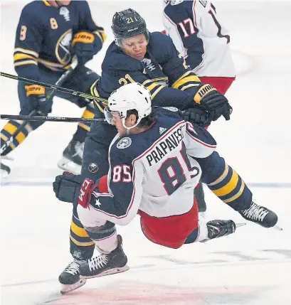  ?? ADRIAN KRAUS THE ASSOCIATED PRESS ?? Sabres winger Kyle Okposo hammers Blue Jackets defenceman Michael Prapavessi­s in pre-season NHL action Tuesday night.