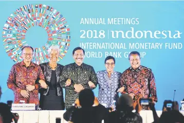  ?? — Reuters photo ?? (Left to right) World Bank Group president Jim Yong Kim, Internatio­nal Monetary Fund managing director Christine Lagarde, Indonesia’s Coordinati­ng Minister for Maritime Affairs Luhut Binsar Pandjaitan, Indonesia’s Finance Minister Sri Mulyani Indrawati and Bank Indonesia governor Perry Warjiyo during the closing of the Internatio­nal Monetary Fund – World Bank Group Annual Meeting 2018 in Nusa Dua, Bali, Indonesia.