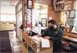  ??  ?? Owner Elmer Palma writes down a to-go order at Elmer’s Diner.