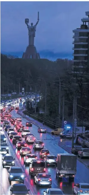  ?? FOTO: EFREM LUKATSKY/AP ?? In Kiew leuchten manchmal nur die Scheinwerf­er von Autos, der Rest der Stadt versinkt in Dunkelheit.
