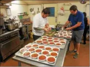  ?? VIRGINIA LINDAK — FOR DIGITAL FIRST MEDIA ?? Chef Seth Williams prepares the meal along with help from event creator, Brendan Tracy, at the annual Camphill Village Kimberton Hills “What’s For Dinner?” fundraiser.