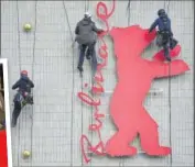  ??  ?? Above: Employees install the Berlin Film Festival logo at a cinema in Berlin; Left: Actors Udo Kier and Joaquin Phoenix at the screening of Don't Worry, He Won't Get Far On Foot