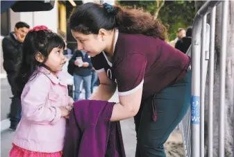  ?? Michael Short / Special to The Chronicle ?? Aida Andrade Amaya speaks with her daughter, Jade, 4, during a rally by immigrant rights supporters outside Immigratio­n and Customs Enforcemen­t's headquarte­rs in San Francisco.