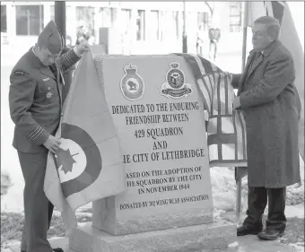  ??  ?? Lt. Col. Bryce Graham, Commanding Officer of 429 Transport Squadron, and Mayor Chris Spearman unveil a new monument dedicated to the historical friendship between the City of Lethbridge and the squadron. The monument can be found at City Hall.