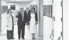  ??  ?? President Trump is accompanie­d by his wife Melania and surgeon Igor Nichiporen­ko during a visit to school shooting victims. JORDAN FABIAN/POOL/EPA-EFE