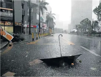  ?? /Reuters ?? Little protection: An umbrella in a street after a rainstorm as Typhoon Mangkhut makes landfall in Guangdong province, in Shenzhen, China, on Sunday.