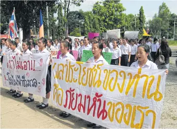  ?? RARINTHORN PETCHAROEN ?? About 200 students and teachers in Nan province hold up placards protesting against the planned building of a biomass power plant in front of their school in Wiang Sa district.