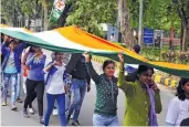 ?? — BUNNY SMITH ?? Youth Congress activists walk under a 500-metre long tri-colour during a peace march in New Delhi on Friday.
