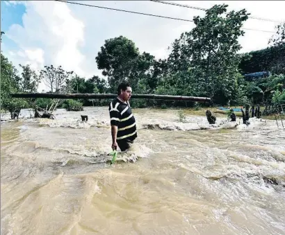  ?? JAIME AVALOS / EFE ?? Un hombre camina por una zona inundada en el estado mexicano de Tabasco