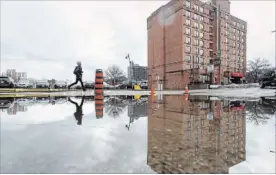  ?? GARY YOKOYAMA THE HAMILTON SPECTATOR ?? A partially flooded parking lot between Bowen Street and Catharine Street, beside 33 Bowen.