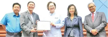  ??  ?? Christina (centre) presenting the Best Tourism Industry Leader Award to Tan. Looking on from left are Yeo, Ho and Amrullah.