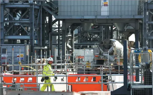  ?? LUKE MACGREGOR / BLOOMBERG ?? A worker walks through the concrete batching area during the early part of pre-constructi­on at the planned Hinkley Point C nuclear power station in the United Kingdom.