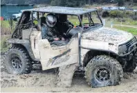  ??  ?? Enjoying the mud . . . Muddy water flows out after driver Alistair Robbie, accompanie­d by codriver Barry Dodd, opens his door.