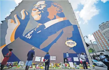  ?? [MIKE STEWART/ THE ASSOCIATED PRESS] ?? People gather at a make-shift memorial near the home of Rep. John Lewis, D-Ga., on Sunday in Atlanta.