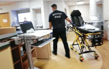  ?? Elizabeth Conley / Staff photograph­er ?? Paramedic Josh Walls walks through Houston Northwest Medical Center with an empty stretcher after dropping off a patient. With hospitals filling with COVID-19 patients, there is little room for others.