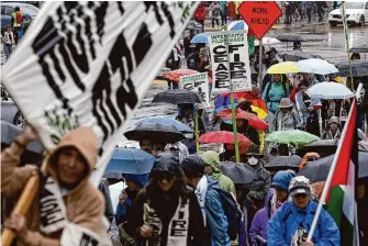  ?? Photos by Yalonda M. James/The Chronicle ?? A crowd marches to the First Congregati­onal Church of Oakland during the 22-mile walk Saturday. The distance reportedly matches what those fleeing Gaza must travel to reach the Rafah crossing.