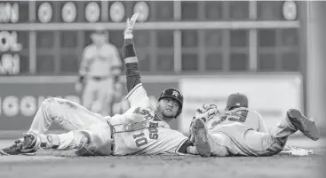  ?? Yi-Chin Lee / Houston Chronicle ?? Astros first baseman Yuli Gurriel (10) signals he is safe at second base as Yankees shortstop Tyler Wade (39) attempts to tag him during the second inning Sunday at Minute Maid Park.