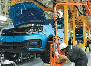  ?? ZHANG GUOJUN / XINHUA ?? Workers carry out checks on an assembly line of new energy vehicles in Fujian province. Key manufactur­ing industries are expected to benefit from the country’s economic policies, including the policy to cut corporate tax burden.