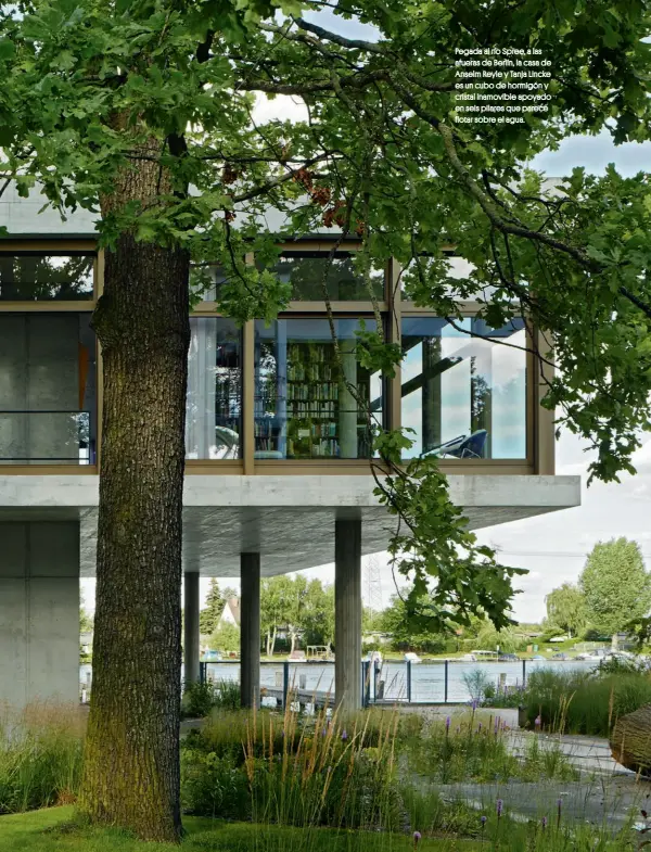  ??  ?? Pegada al río Spree, a las afueras de Berlín, la casa de Anselm Reyle y Tanja Lincke es un cubo de hormigón y cristal inamovible apoyado en seis pilares que parece flotar sobre el agua.